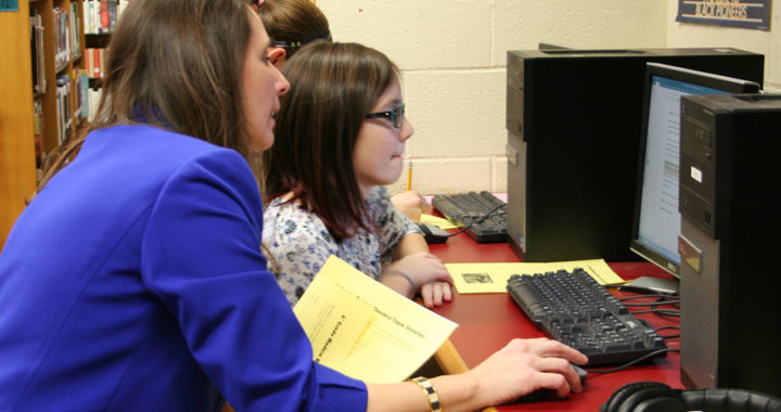 Library Media Specialist Linda Fecura works with student