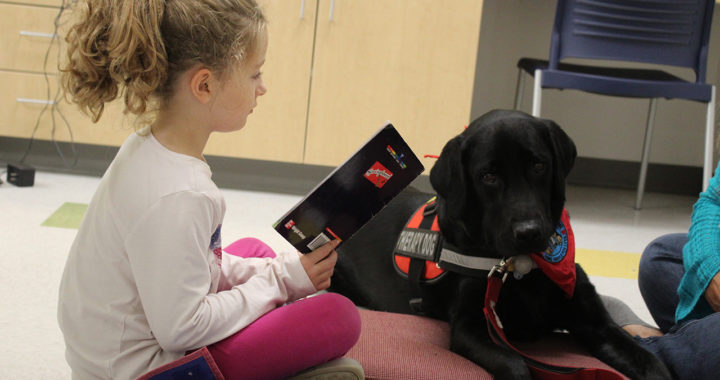 Student reads to therapy dog