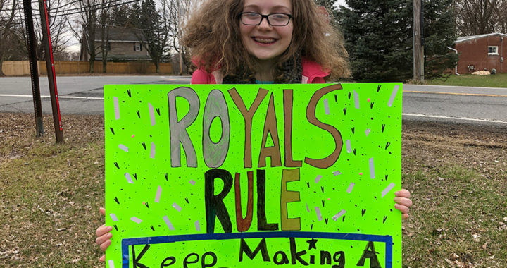 Student with Royals Rule poster